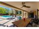 Covered patio with dining area overlooking the backyard pool and lush greenery at 3601 N 55Th Pl, Phoenix, AZ 85018