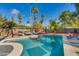 Sparkling pool with volleyball net and lounge chairs, surrounded by lush landscaping and a sunny sky at 3601 N 55Th Pl, Phoenix, AZ 85018