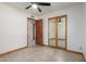 This bedroom features tile flooring, a ceiling fan, and a closet with mirrored sliding doors at 3801 W Barnes Ln, Phoenix, AZ 85051