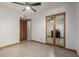Bedroom with tile flooring, a sliding mirror door closet and a natural wood door at 3801 W Barnes Ln, Phoenix, AZ 85051