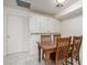 Bright dining area boasts a wooden table set, white cabinets and modern flooring at 3801 W Barnes Ln, Phoenix, AZ 85051