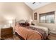 Bright bedroom with a queen-size bed and wood nightstand at 40061 W Sanders Way, Maricopa, AZ 85138