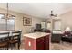 Open kitchen with island, dark wood cabinets, and a view of living room at 40061 W Sanders Way, Maricopa, AZ 85138