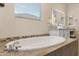 Elegant bathroom with soaking tub, double vanity, and a large mirror at 4103 E Mead Way, Chandler, AZ 85249