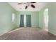 Well-lit bedroom featuring a ceiling fan and en-suite bathroom access at 41405 W Cielo Ln, Maricopa, AZ 85138