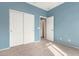 Bedroom with light blue walls, carpet, and double doors at 41405 W Cielo Ln, Maricopa, AZ 85138