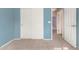 Light blue walls, carpet flooring, and door to hallway at 41405 W Cielo Ln, Maricopa, AZ 85138