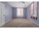 Light purple walls, carpet flooring, and a window at 41405 W Cielo Ln, Maricopa, AZ 85138