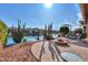 Landscaped backyard with a fire pit and lake view at 42413 W Abbey Rd, Maricopa, AZ 85138