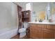 Clean bathroom with wood vanity and shower/tub combo at 42413 W Abbey Rd, Maricopa, AZ 85138