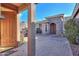 Private courtyard entry with brick flooring and a wood door at 42413 W Abbey Rd, Maricopa, AZ 85138