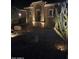 Night view of the front yard with desert landscaping and exterior lighting illuminating the home's facade at 42413 W Abbey Rd, Maricopa, AZ 85138