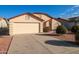 Front view of a beige house with a two-car garage and small front yard at 4872 E Sandwick Dr, San Tan Valley, AZ 85140