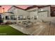 An outdoor area boasts a spa and a pool against the backdrop of a two-story home with multiple balconies at 5427 E Wonderview Rd, Phoenix, AZ 85018