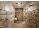 Extensive tiled shower room, featuring multiple shower heads and body sprays, with a built-in bench for comfort at 5427 E Wonderview Rd, Phoenix, AZ 85018