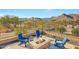 Relaxing fire pit and seating area with mountain backdrop at 5566 N 206Th Gln, Buckeye, AZ 85396