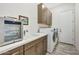 Bright laundry room with sink, cabinets, and new appliances at 5566 N 206Th Gln, Buckeye, AZ 85396