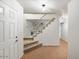 A carpeted staircase with a white railing in a light-toned foyer at 7447 E Christmas Cholla Dr, Scottsdale, AZ 85255