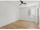 Bright bedroom with hardwood floors, ceiling fan, and window shutters at 7603 W Encinas Ln, Phoenix, AZ 85043