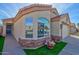 Close-up of stucco home with manicured lawn, stone accents and an attached two-car garage at 1041 N 91St Pl, Mesa, AZ 85207