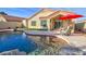 Backyard pool area, rock features, synthetic lawn, and patio make this a perfect space for entertaining at 1041 N 91St Pl, Mesa, AZ 85207