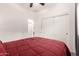 Bedroom with a red comforter and sliding door closet at 10454 E Peralta Canyon Dr, Gold Canyon, AZ 85118