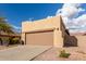 Tan house with a brown garage door and desert landscaping at 10454 E Peralta Canyon Dr, Gold Canyon, AZ 85118