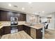 Modern kitchen with dark wood cabinets, stainless steel appliances, and tile floors at 10730 E Medina Ave, Mesa, AZ 85209