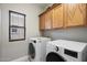 Bright laundry room featuring washer, dryer, and ample cabinetry at 10730 E Medina Ave, Mesa, AZ 85209