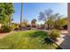 Landscaped backyard with grassy area, pool, and fountain at 10921 W Bermuda Dr, Avondale, AZ 85392