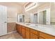 Bathroom with double sinks, wood cabinets, and a large mirror at 10921 W Bermuda Dr, Avondale, AZ 85392