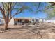 Backyard featuring gravel landscaping, mature trees providing shade, and a covered patio at 11008 W Cherry Hills W Dr, Sun City, AZ 85351