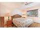 Cozy bedroom with a ceiling fan, natural light, and a comfortable bed at 11008 W Cherry Hills W Dr, Sun City, AZ 85351