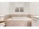 Relaxing bathroom featuring a soaking tub and window with plantation shutters at 11673 N 136Th St # 1021, Scottsdale, AZ 85259