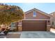 Single-story home with brown garage door and landscaping at 12021 W Locust Ln, Avondale, AZ 85323