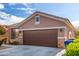 Single-story home with brown garage door and landscaping at 12021 W Locust Ln, Avondale, AZ 85323