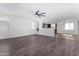 Open living room with kitchen view, wood-look floors, and ceiling fan at 12021 W Locust Ln, Avondale, AZ 85323