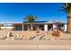 Ranch-style home with carport, desert landscaping, and palm trees at 12406 W Allegro Dr, Sun City West, AZ 85375