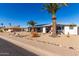 House exterior with palm trees, landscaping, and a paved driveway at 12406 W Allegro Dr, Sun City West, AZ 85375