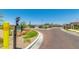 Well-maintained community entrance with brick-paved road, landscaped island, and security access point at 1255 N Arizona Ave # 1297, Chandler, AZ 85225