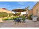 Stone patio features umbrella, table, chairs, and grill at 14204 N Bursage Dr, Fountain Hills, AZ 85268