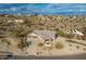 An aerial view showcasing a single-story house, a paved driveway, and a desert landscape at 16548 E Emerald Dr, Fountain Hills, AZ 85268