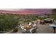 Sunset view of backyard patio with fire pit, seating, and hot tub at 16548 E Emerald Dr, Fountain Hills, AZ 85268