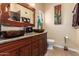 Unique bathroom with double sinks, wood vanity, and artistic mirror at 16548 E Emerald Dr, Fountain Hills, AZ 85268