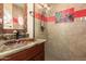 Bathroom with copper sink, red tile accents and a walk-in shower at 16548 E Emerald Dr, Fountain Hills, AZ 85268