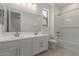 Bright bathroom featuring double sinks, tiled floors, and a shower-tub combo at 18225 W Hess St, Goodyear, AZ 85338