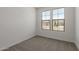 This airy bedroom has neutral carpet and dual windows offering exterior views at 18225 W Hess St, Goodyear, AZ 85338