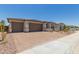 Home exterior displaying a three-car garage, brick driveway, and well-manicured landscaping at 18225 W Hess St, Goodyear, AZ 85338