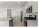 Well-lit kitchen with stainless steel appliances and white cabinets at 18225 W Hess St, Goodyear, AZ 85338