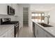 Open kitchen with stainless steel appliances, white cabinets, and a pantry at 18225 W Hess St, Goodyear, AZ 85338